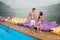 Young romantic couple with perfect bodies standing near swimming pool
