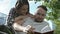 Young romantic couple sitting in park and reading book.