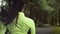 Young runner brunnete woman in green blouse running in park