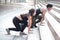 Young runner man and woman lover doing exercise together outside, partner buddy runner stretching body at staircase before run