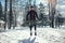 Young runner in sportswear jumping on snow covered winter road