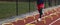 Young runners wearing black spandex running over yellow mini hurdles