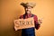 Young rural farmer man wearing countryside hat on strike prostest for salary very happy pointing with hand and finger to the side