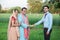 Young rural indian couple farmer receive money from banker at agriculture field