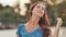 A young Russian girl with happy emotions is walking along the beach and posing in front of the camera. Close-up. The