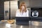 Young Russian woman looking at laptop computer in a kitchen