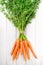 Young rustic carrots on white boards