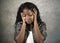 Young sad and depressed black African American woman holding her head feeling sick and stressed on studio background suff