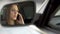Young sad female sitting on driver\'s seat and talking with boyfriend, break-up