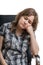 Young sad woman sitting on chair. on white background.