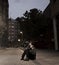 Young sad woman sitting on street ground at night alone desperate