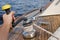 Young sailor pulling rope on sailboat