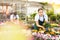 Young salesgirl arranging pots with blooming gazania in garden store