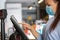 Young saleswoman doing process payment on the touchscreen POS, counting sale in the cash register, finance concept