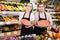 Young saleswoman and salesman holding half of watermelon in hands in fruit store