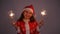 Young santa claus woman in red christmas or new year coat and hat holding sparkler