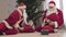 Young Santa stealing gift sack from senior Clause. Two men in red Christmas costumes pulling bag with presents. New Year