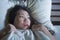 Young scared and stressed Asian Chinese woman lying in bed suffering nightmare in fear and panic grasping blanket covering her hor