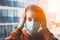 Young scared woman wearing surgical mask because of viruses and air pollution in the city