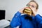 Young school boy eating hamburger