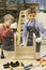 Young school boys tightening screws in wooden stool