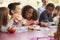 Young school kids eating lunch talking at a table together