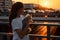 Young schoolgirl with dog at looks at sunset.