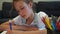 Young schoolgirl drawing eye at home.