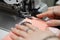 A young schoolgirl learns to sew face masks during a pandemic on an overlock sewing machine