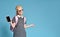 Young schoolgirl shows smartphone on blue background