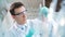 Young scientist checking test tubes in the lab. Man wears protective goggles