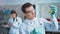 Young scientist checking test tubes in the lab. Man wears protective goggles