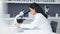 Young scientist using a digital tablet and microscope in a lab. Female pathologist analyzing medical samples while doing