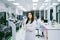 young scientist in white lab coat standing with automation blood analyzer at medical laboratory