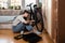 Young self learned woman or girl mechanic fixing and repairing her bicycle at her home. Female repair chain on rear wheel before