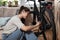 Young self learned woman or girl mechanic fixing and repairing her bicycle at her home. Female repair chain on rear wheel before