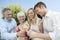 Young And Senior Couple Toasting Champagne Flutes Outdoors