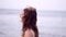 Young sensual woman with streaming hair walking at beach