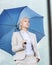 Young serious businesswoman with umbrella outdoors