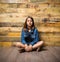 Young serious girl sitting on floor