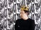 Young serious man in black shirt and gold crown