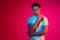 Young serious man posing isolated on magenta studio background in neon light, Concept of human emotions, facial