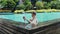 Young serious man take pictures, make photo on smartphone standing in swimming pool at luxury tropical hotel, resort