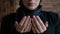 Young serious Muslim woman in hijab raises her hand and prays. Close-up praying namaz muslim woman. Traditional Islamic