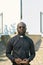 Young serious priest in black shirt with clerical collar holding Holy Bible