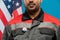 Young serious repairman of Hispanic ethnicity with vote insignia on uniform