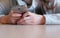 Young seriously woman reading something on her mobile phone sitting in cafe. Closeup hands.