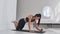 Young sexy brunette woman in sportswear doing side plank exercise shifts hands while kneeling in white beautiful