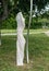 Young sexy elegant woman, her body wrapped in long skin tight white dress, highlighting body shapes, as living statue work of art