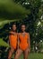 Young sexy girls in orange swimsuits posing in a tropical villa in greenery